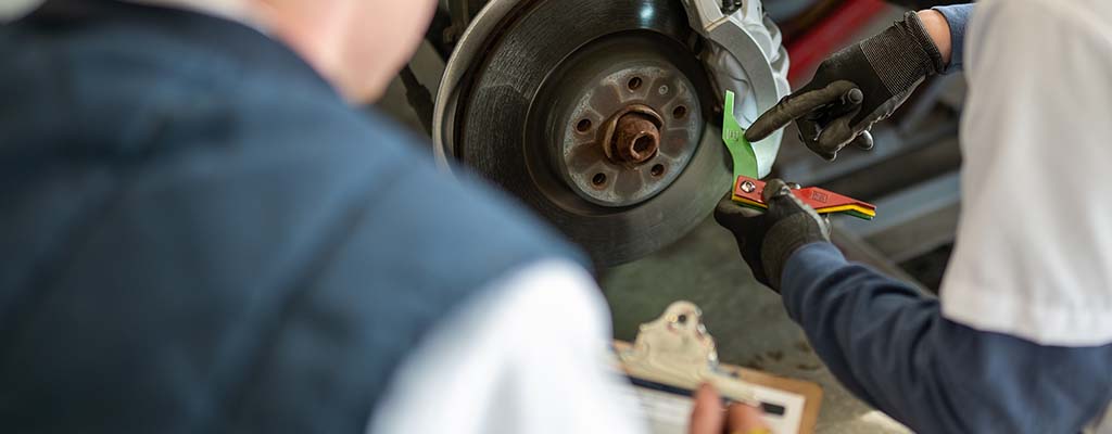 Mechanic working on a vehicle's brakes.