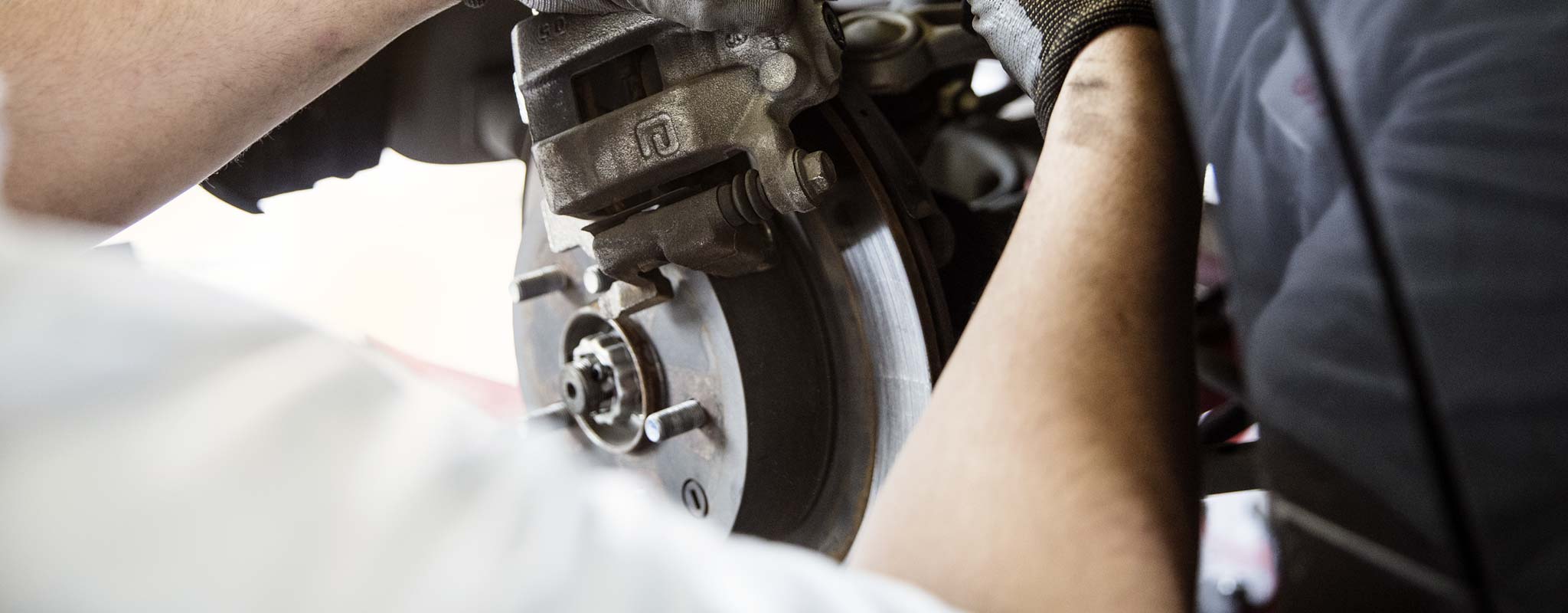 Close up view of a technician working on a brake system.