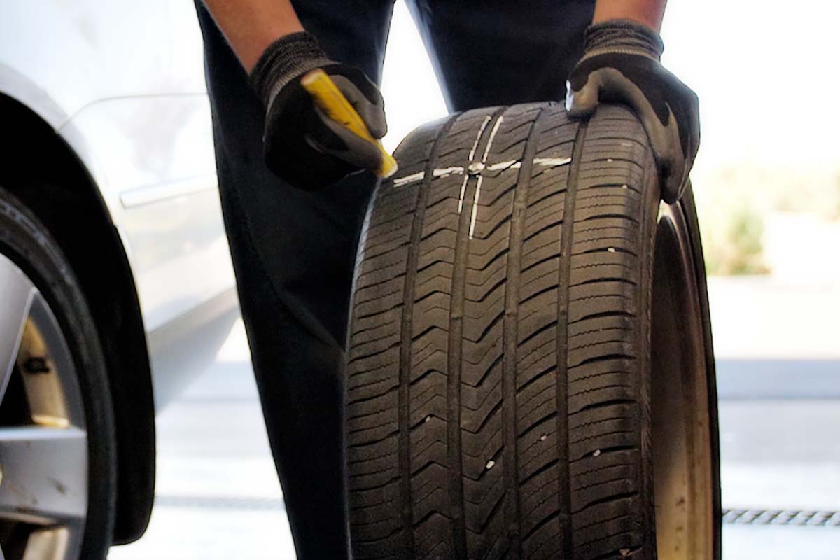 Les Schwab technician marking the cause of a flat tire.