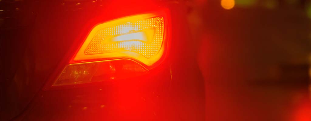 Illuminated car brake light at night.