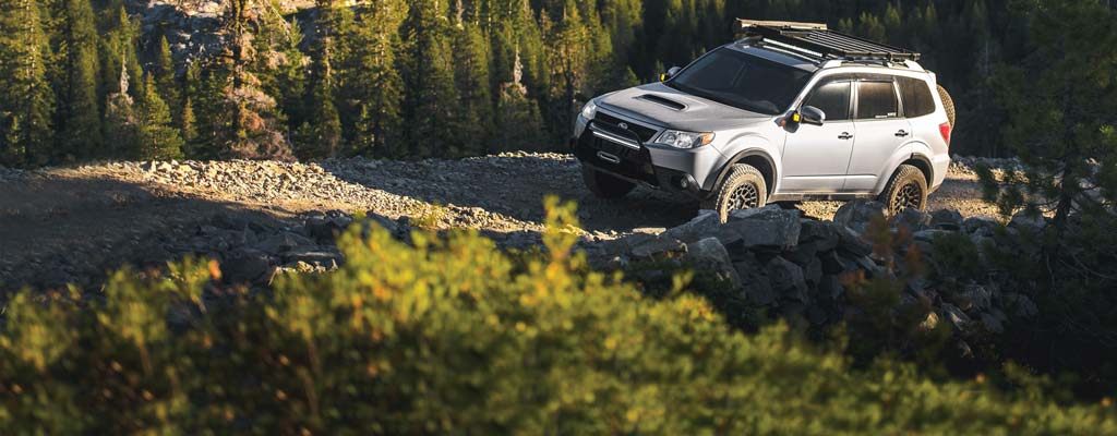 Silver Subaru Forester on a gravel mountain road