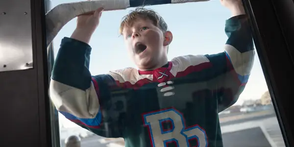 Young hockey player waiting at a door