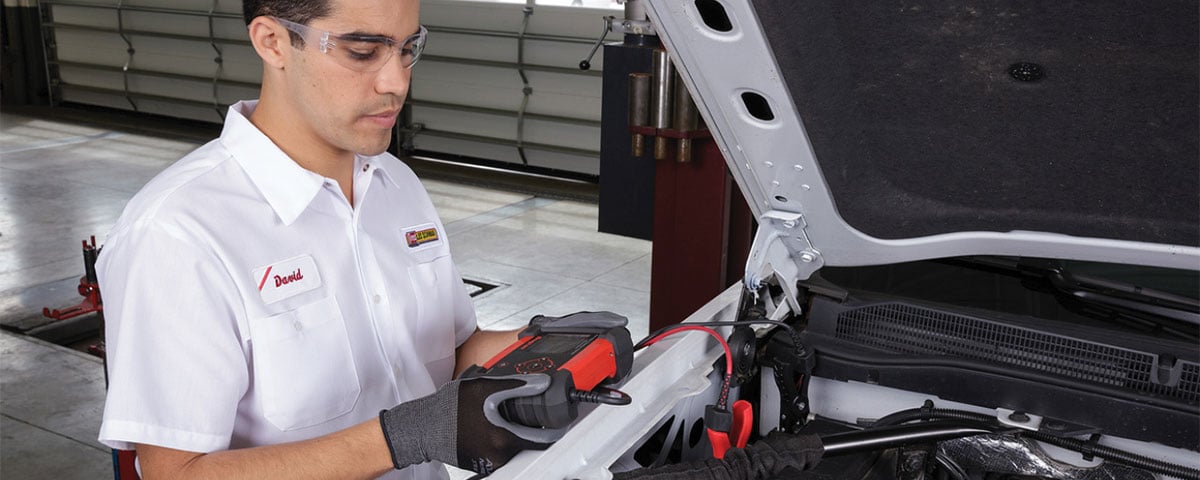 Technician checking auto battery charge