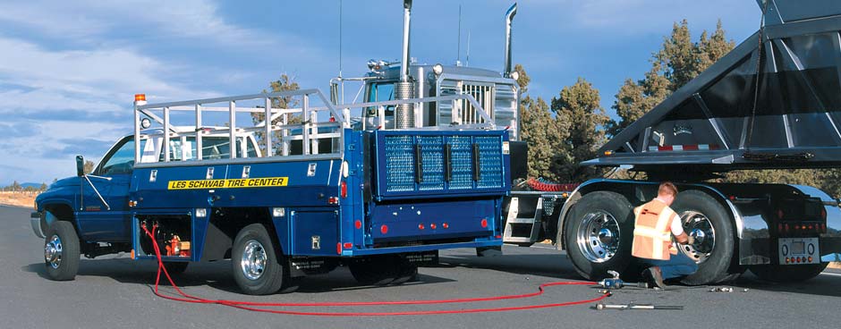 Les Employee performing roadside service on a commercial belly-dump truck.