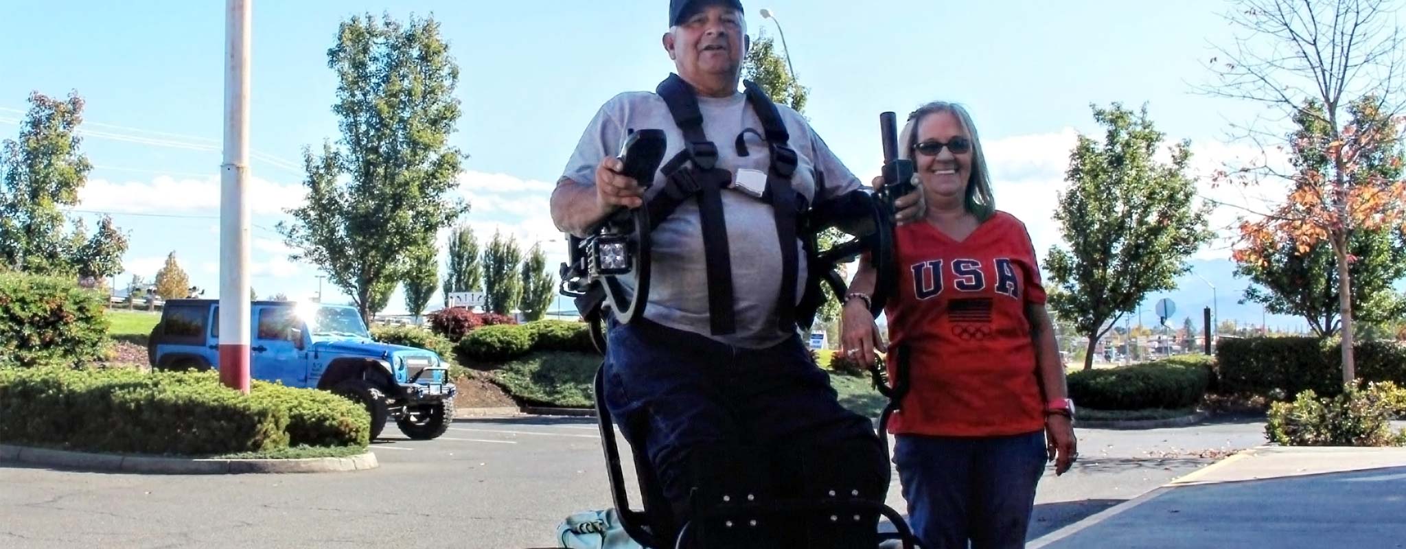 George Myers in a wheelchair that allows him to stand, next to wife Debbie.