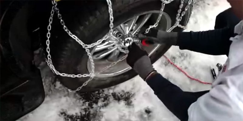 Les Schwab technician putting on snow chains