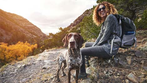 Woman resting on a hike with her dog.