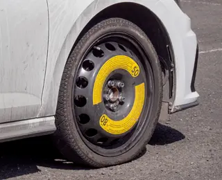 White car with space-saver spare installed.