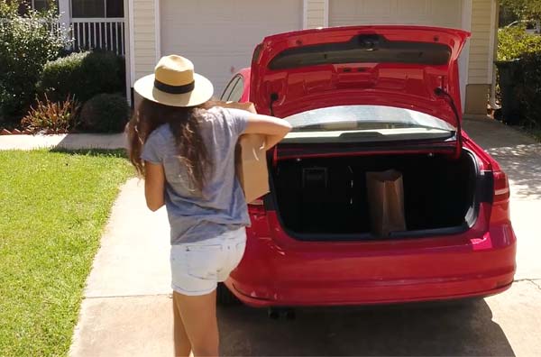Woman unloading groceries from her trunk