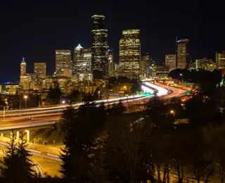 Seattle freeway and skyline at night with car light trails.