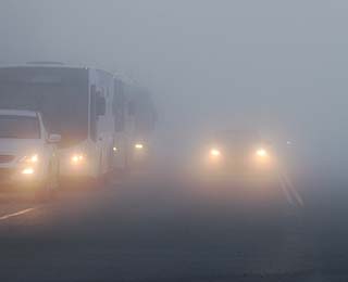 Vehicles on a foggy highway.