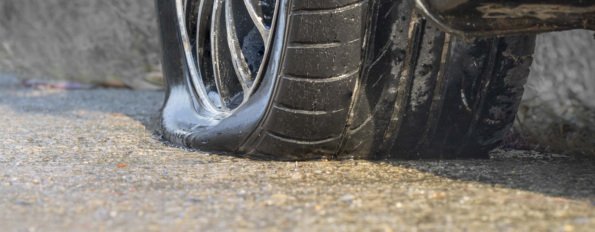 Flat car tire on a wet road.