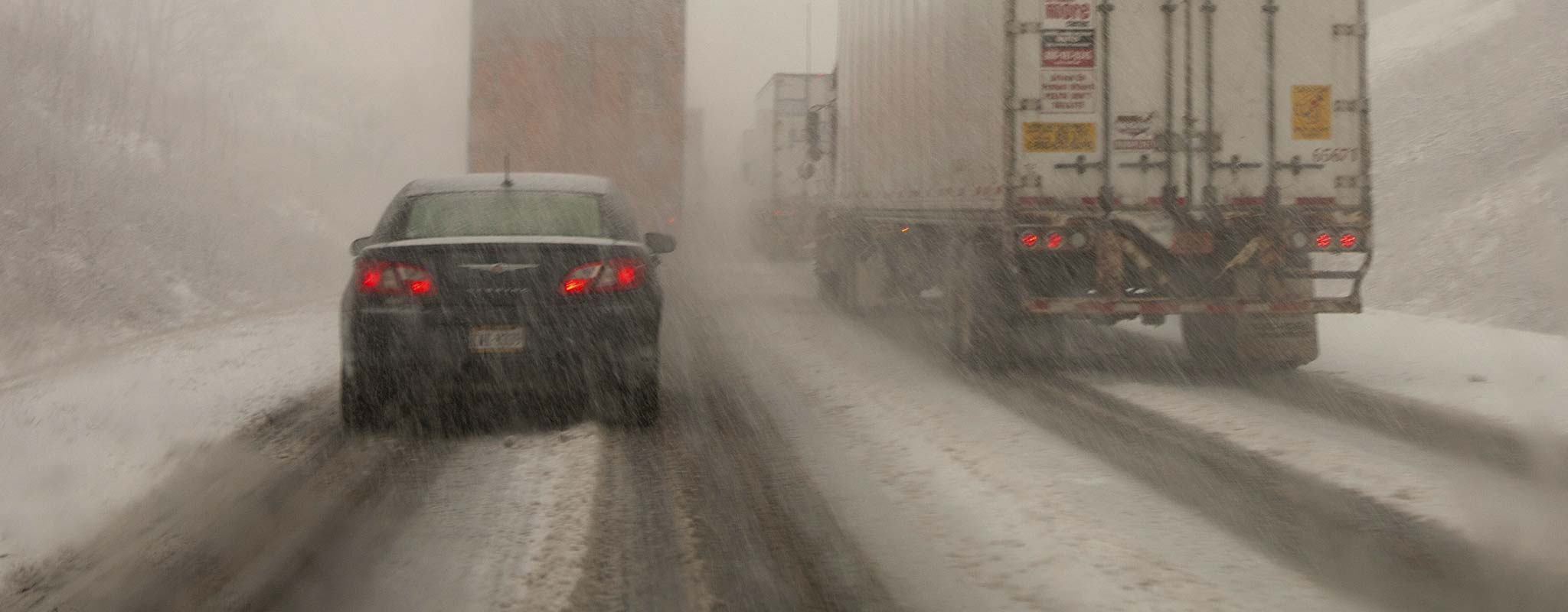 Cars and trucks on a snowy mountain pass.