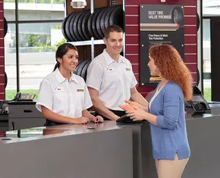 Les Schwab employees assist a customer in choosing the right tires.
