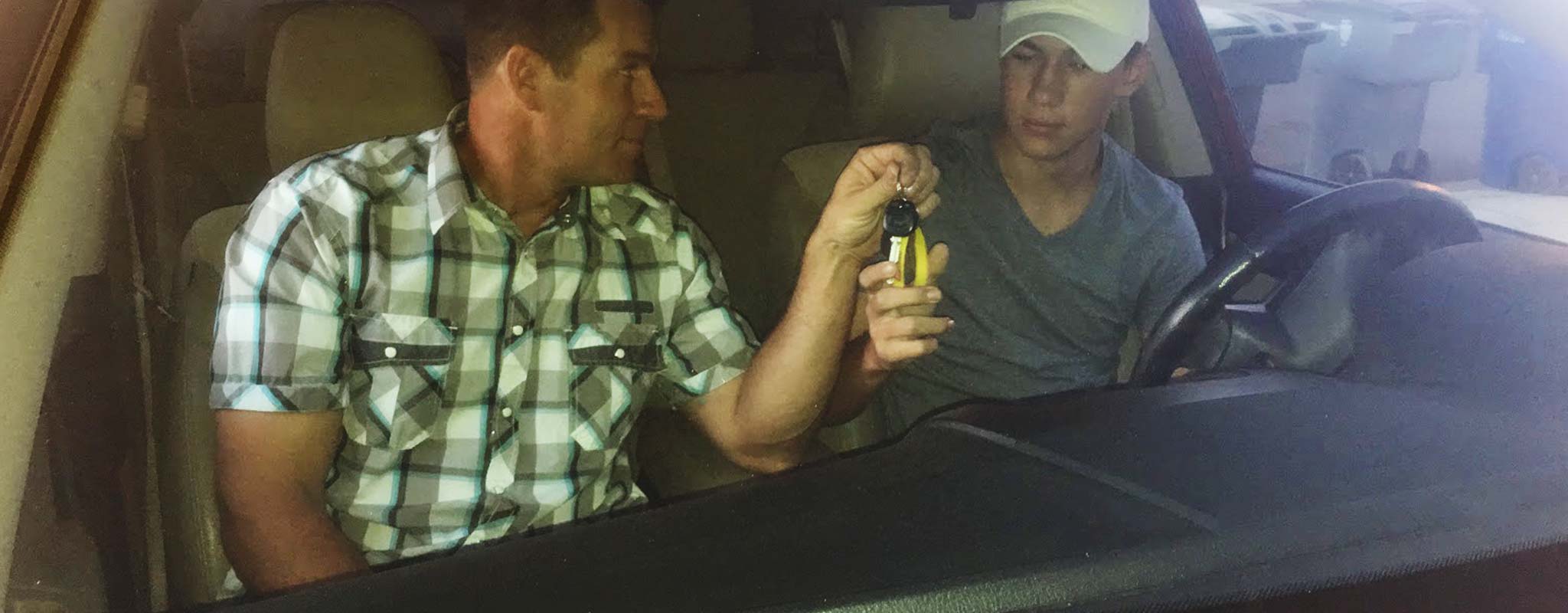 Les Schwab manager, Matt Clift hands his son, Lane, a set of car keys.