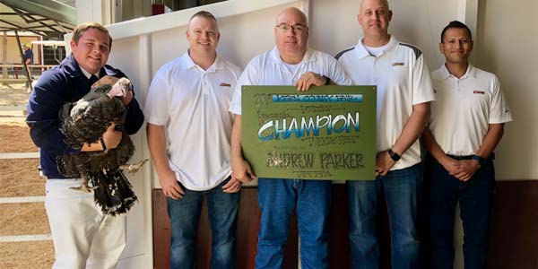 Bakersfield Les Schwab managers pose with Andrew Parker and his Reserve Champion Turkey Hen.