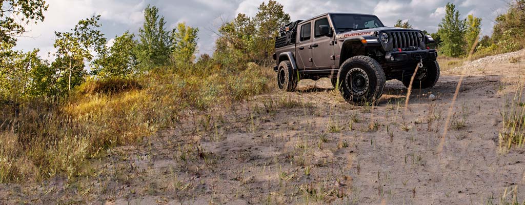 A Jeep with custom wheels and off-road tires