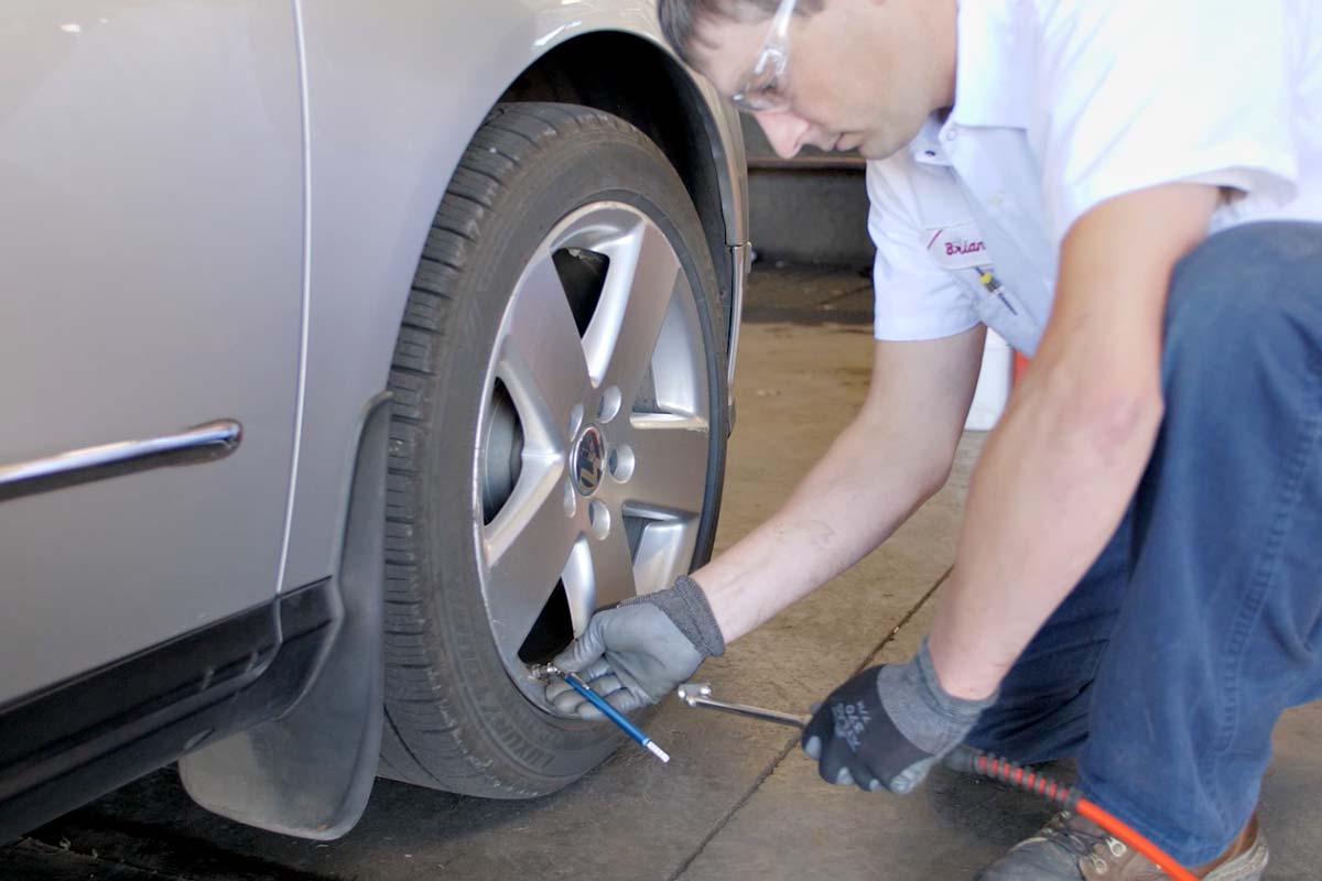 Les Schwab technician checking the tire pressure on remaining tires.