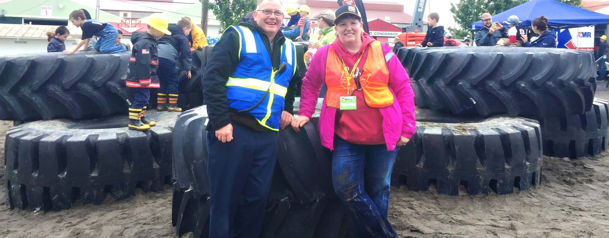 Woodland Les Schwab manager Brien Rose and his wife supervising children playing on giant tires at Dozer Day in Vancouver.