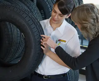 A Les Schwab tire expert explains tire tread and more to a customer