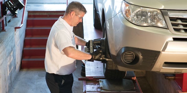 A Les Schwab technician performing an alignment on a car.