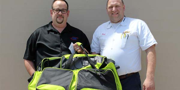 Mike stands next to a Les Schwab manager.