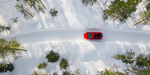 Red car driving on snowy road