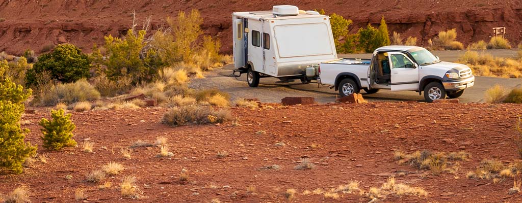 Pickup and camp trailer parked roadside in a Utah National park.