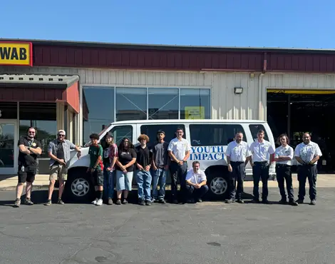 Youth Impact van and employees in front of Les Schwab