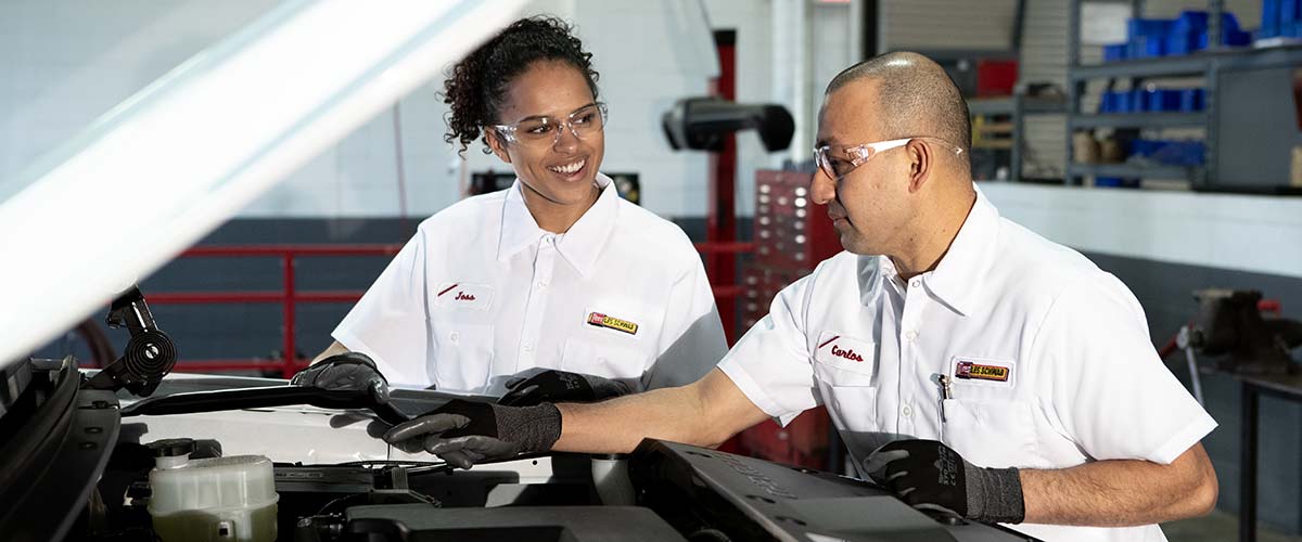 Technicians reviewing a car battery