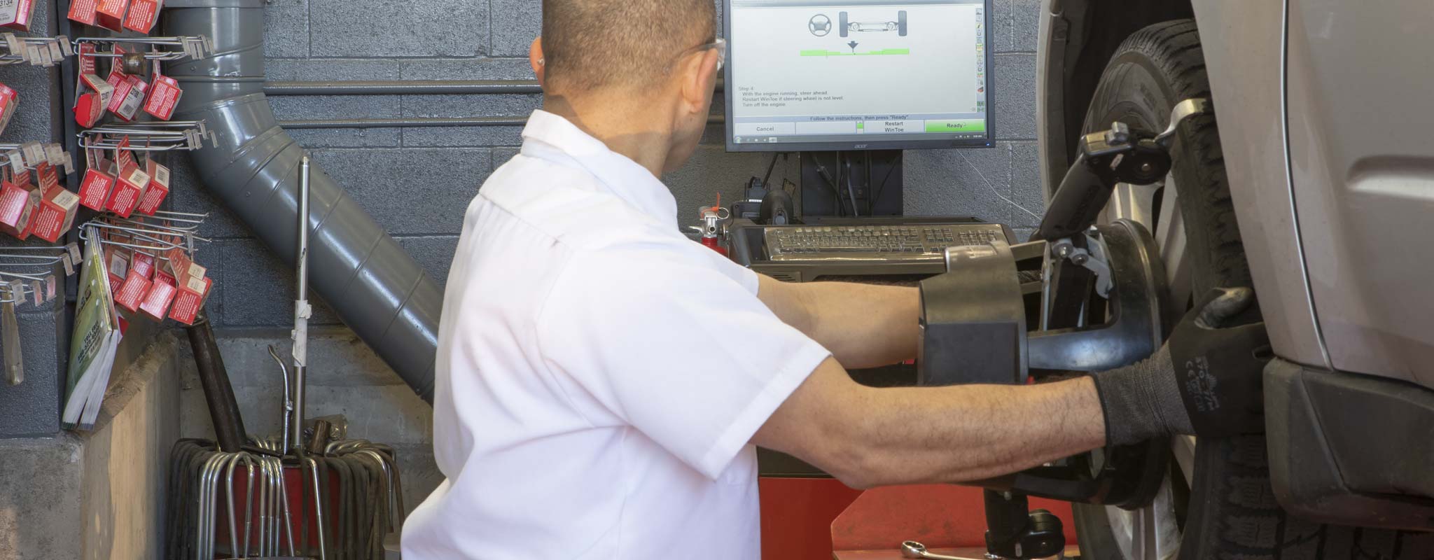 Technician reading the computer monitor as he performs an allgnment.