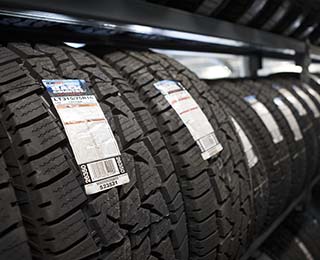 A row of new tires sitting on metal shelving.