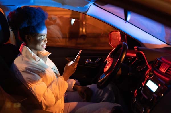 Woman reading cell phone while car idles