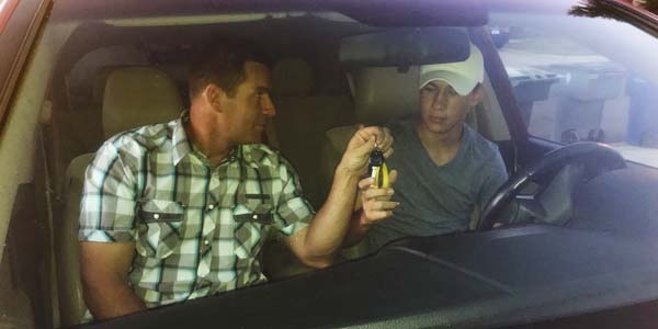 Les Schwab manager, Matt Clift hands his son, Lane, a set of car keys.
