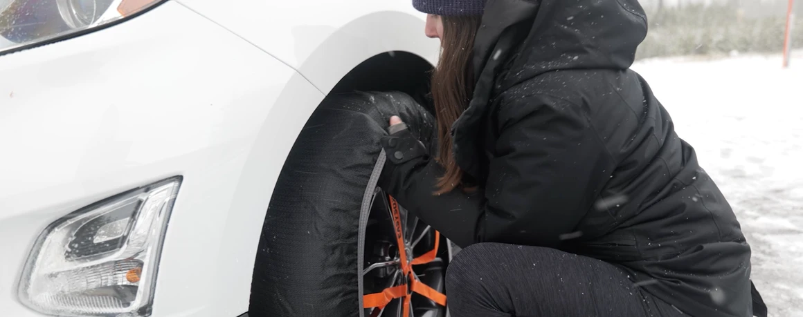 Person adjusts tire socks so they are secure and centered on the wheel.