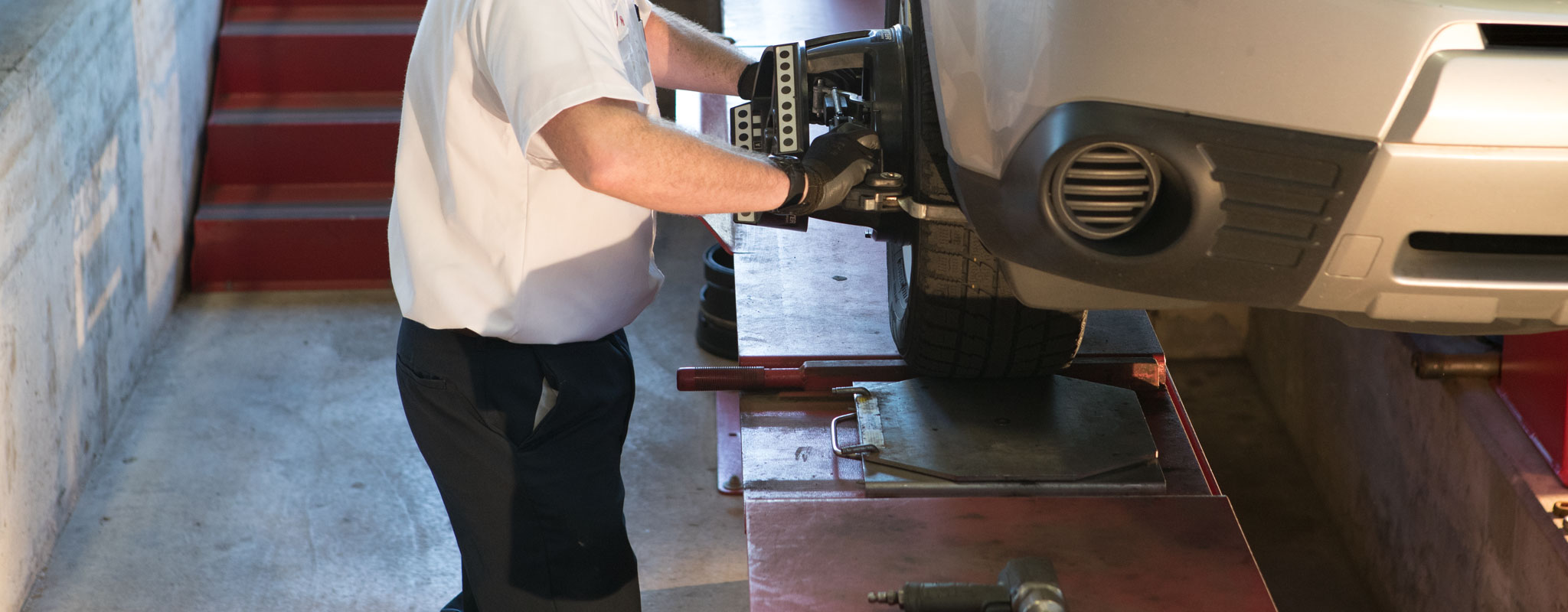 A Les Schwab technician performing an alignment on a car.