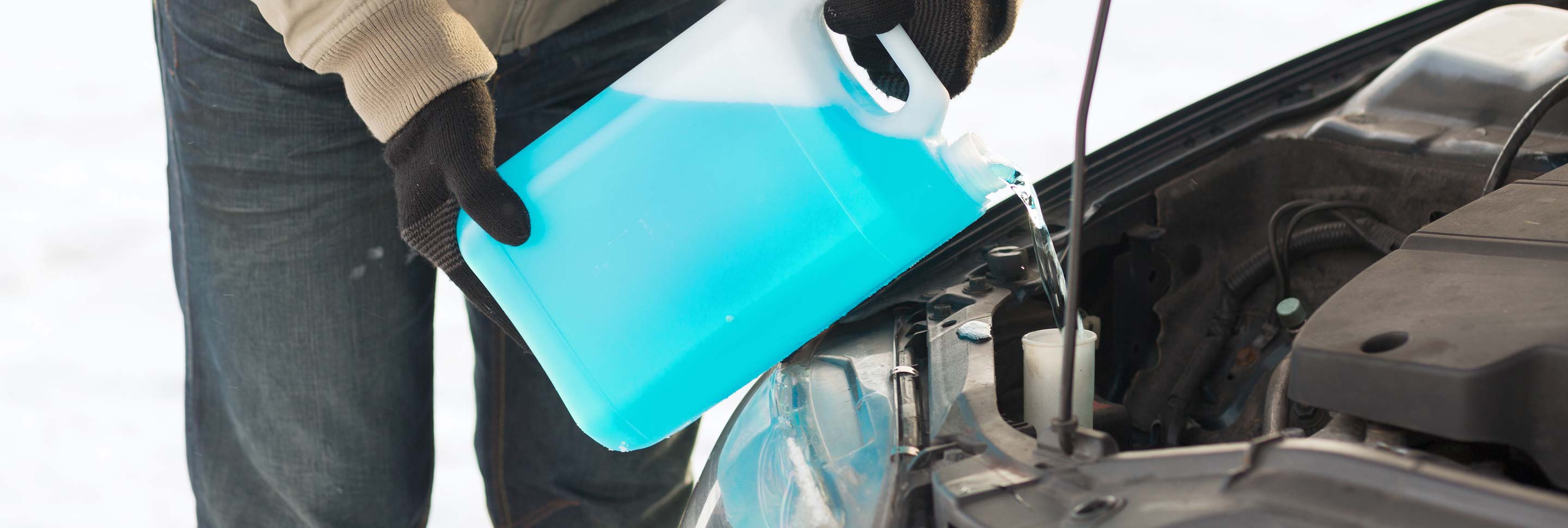 A man adding anti-freeze to his car.