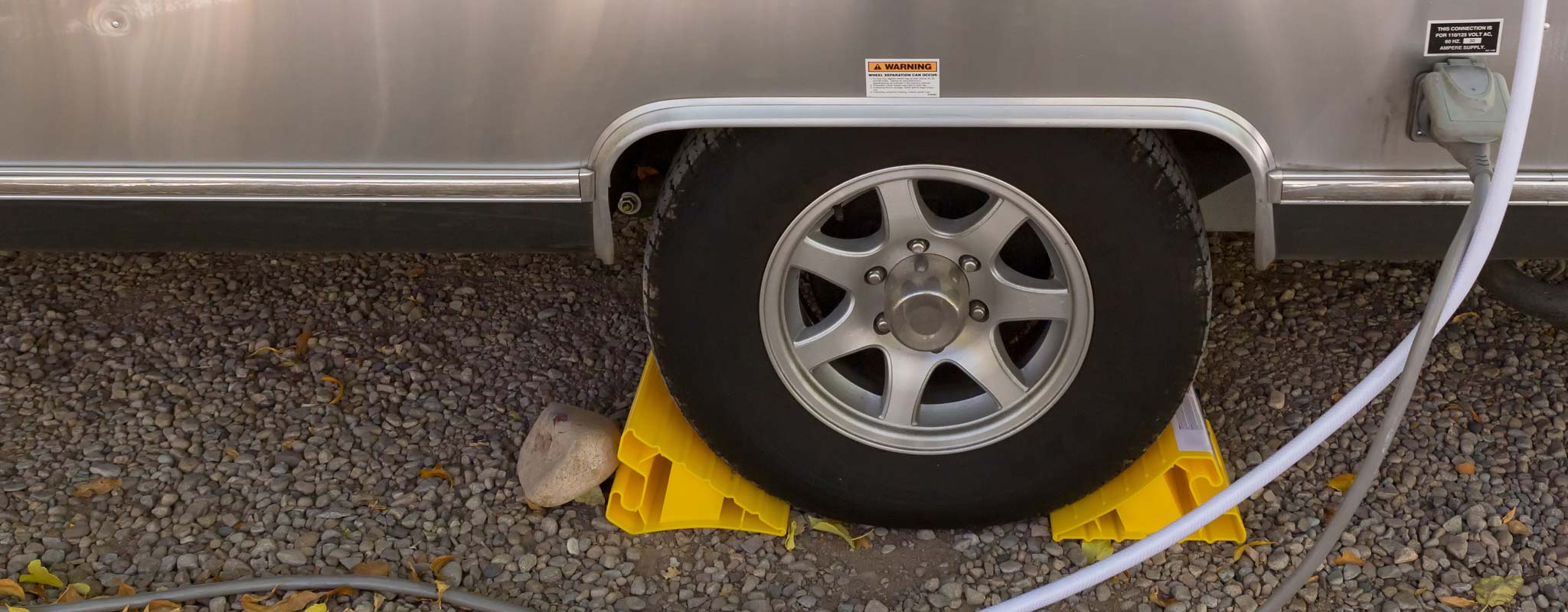 An tire with tire blocks on an aluminum sided RV.