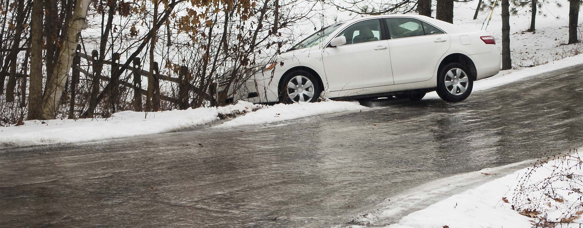 A car in the ditch after sliding off an icy road.