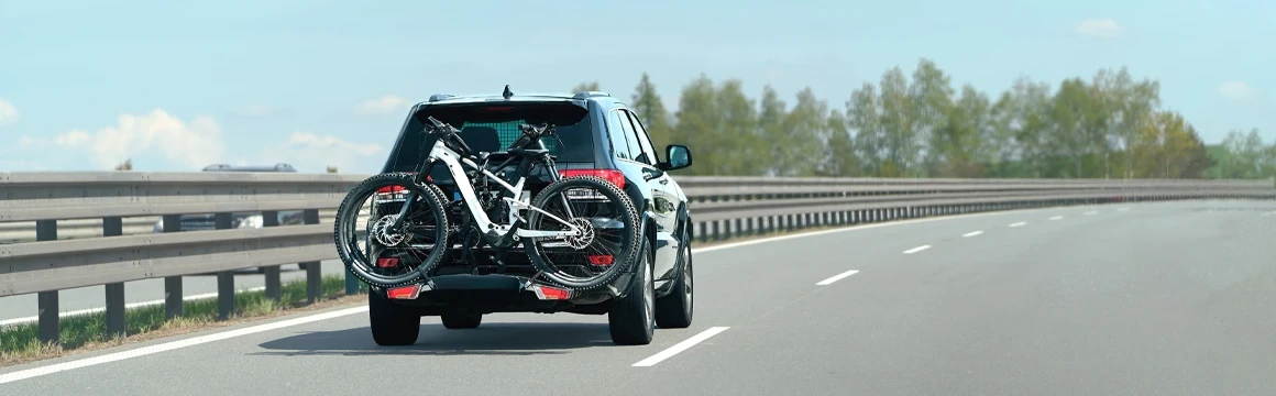 Small SUV with bicycles driving down the highway