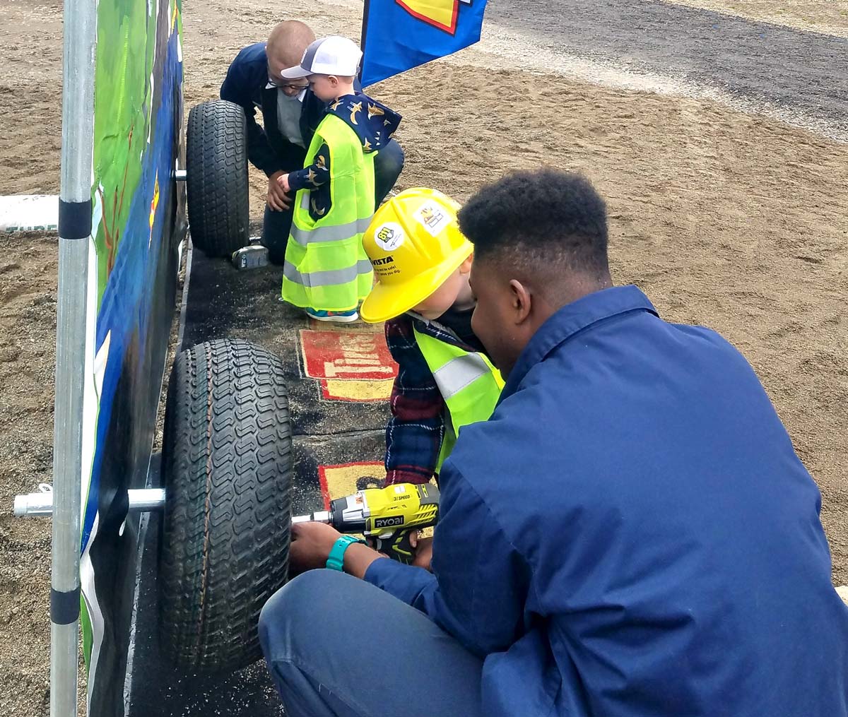 Les Schwab employees teaching kids how to remove lug nuts.