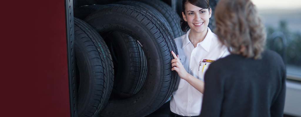 A Les Schwab employee explains tire benefits to a customer.
