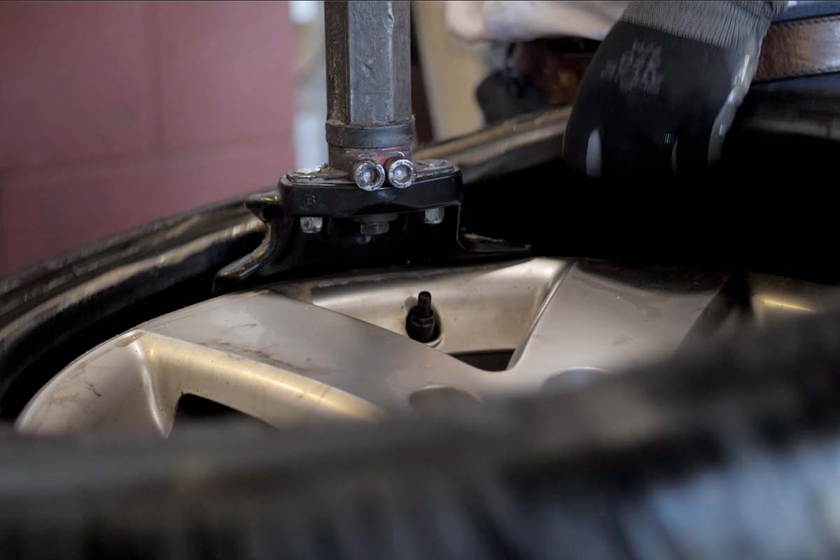 Removing a flat tire from a wheel for repair.