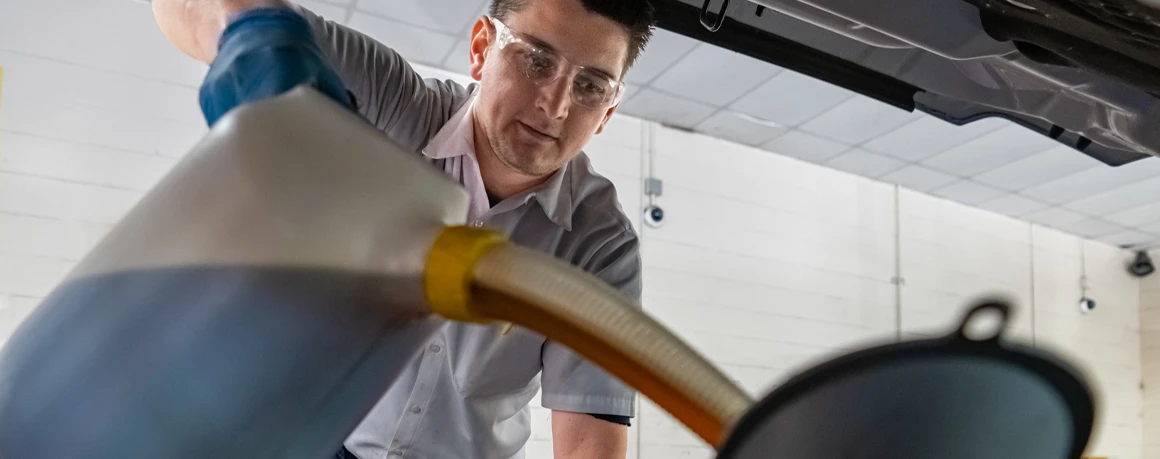 Les Schwab employee changing the oil in a customer’s car