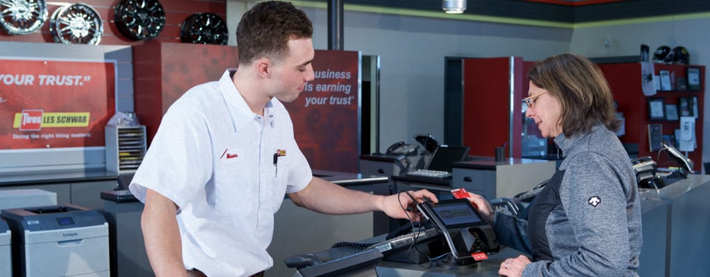 A Les Schwab employee helping a customer with their credit card