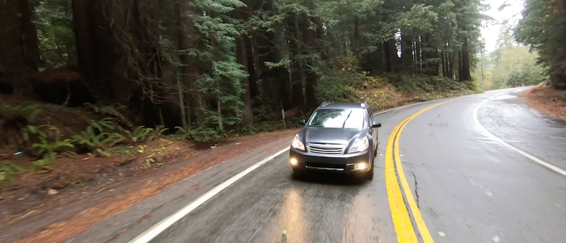 Vehicle driving in the rain over a mountain pass