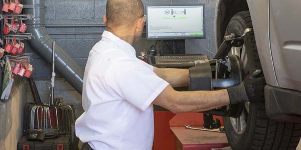 Technician reading the computer monitor as he performs an allgnment.