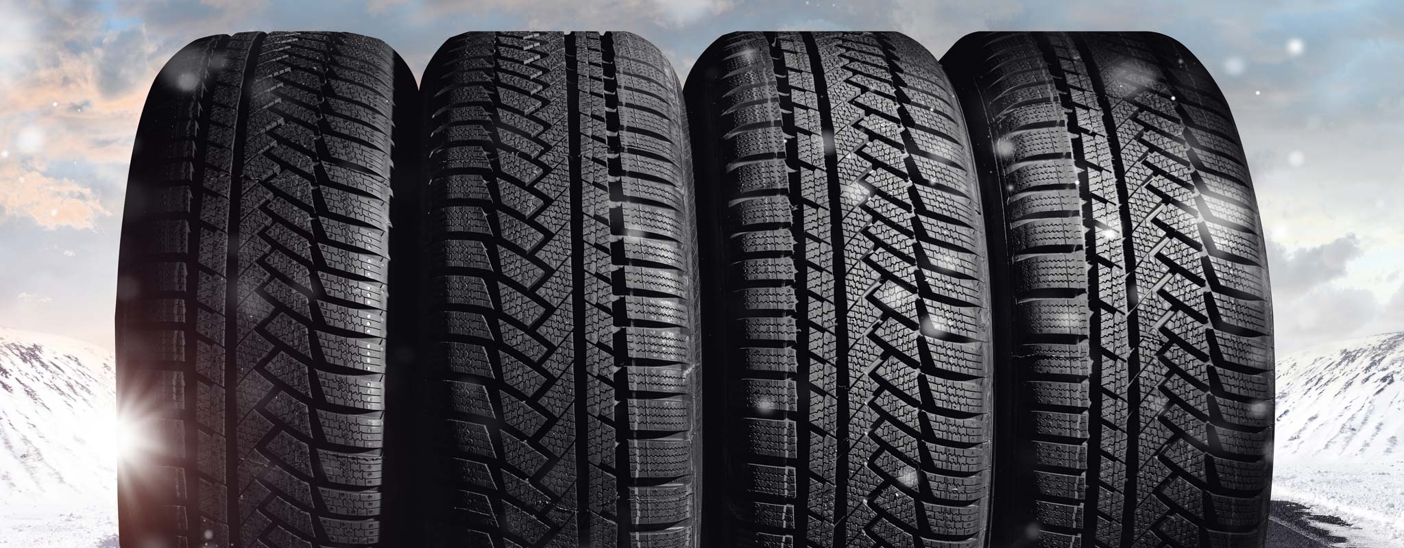 Winter tires lined up on a snowy backdrop