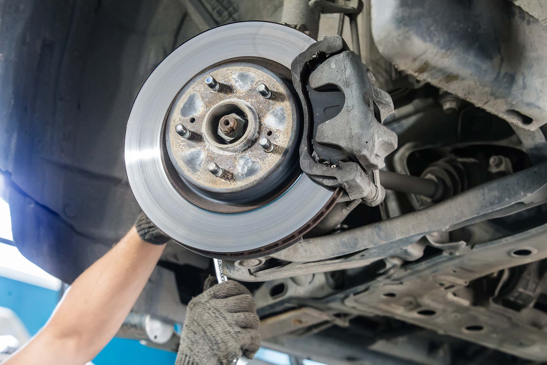 Technician adjusting disc brake on car