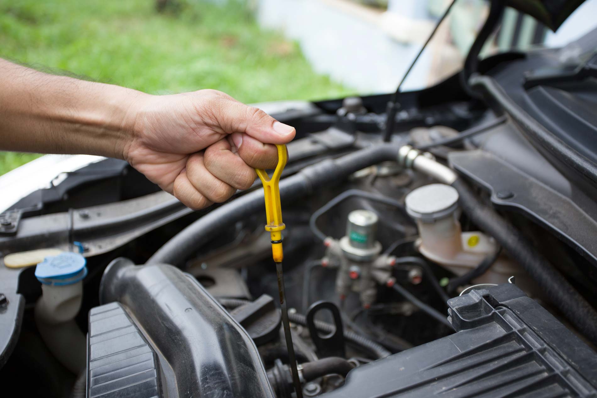 Person checking oil in car